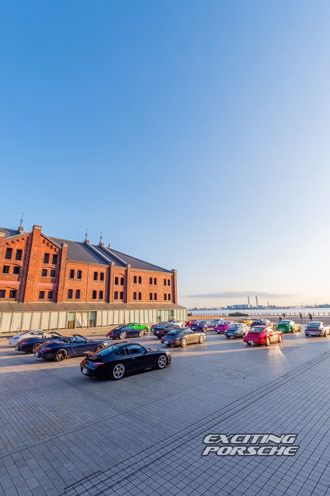 2026 年 EXCITING PORSCHE(横浜 赤レンガ倉庫)で、夕方の広場に参加者のポルシェが並ぶ様子